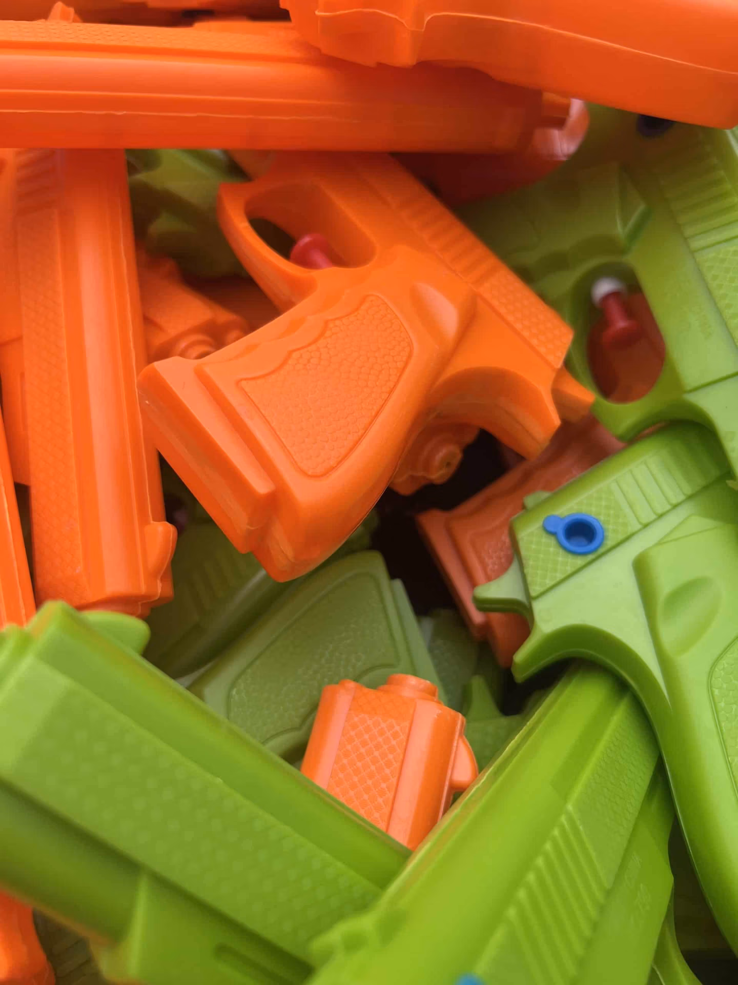 vue zoomée sur le lot de pistolet à eau vert et orange