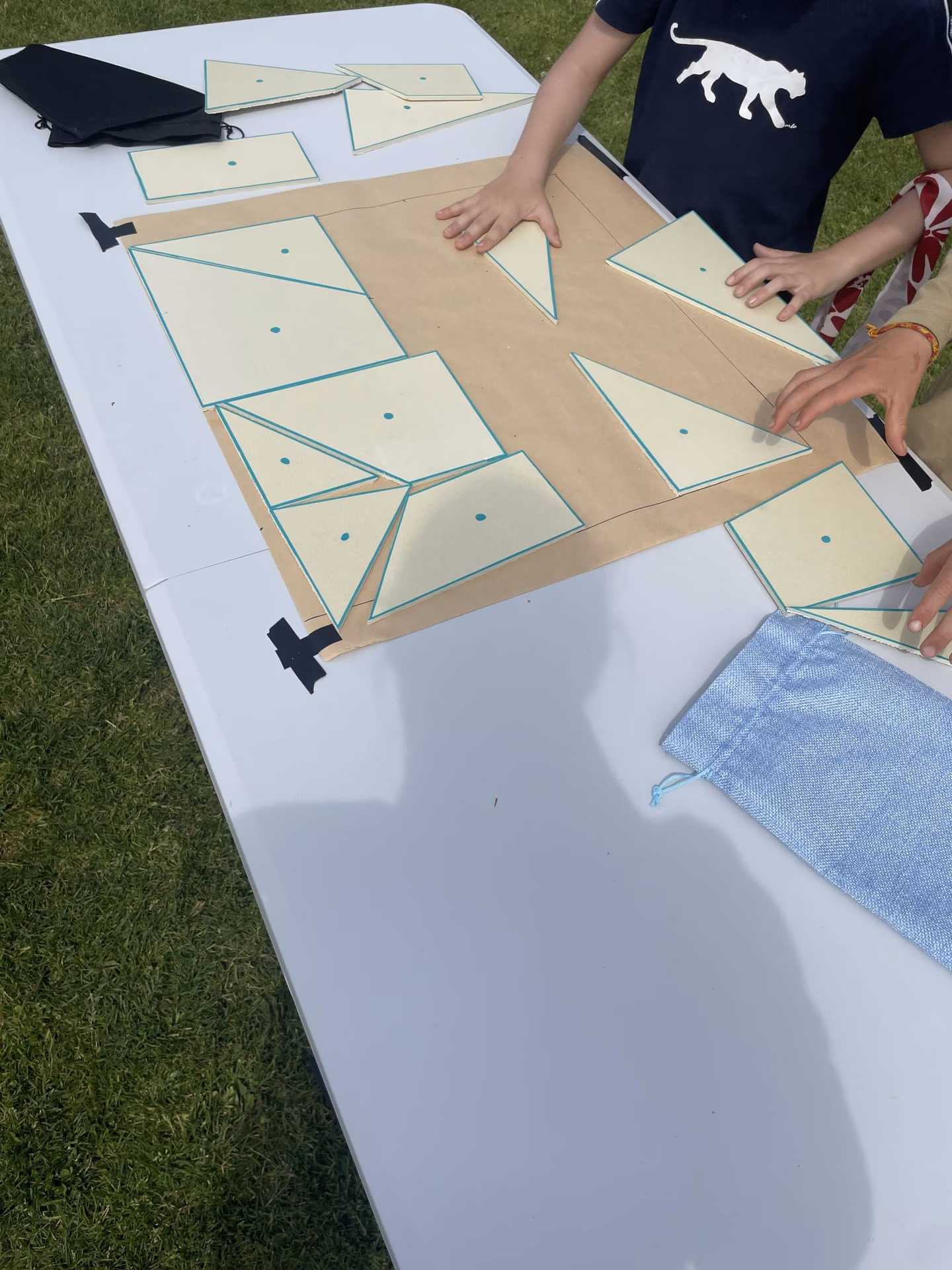 Jeu du tangram géant avec des participants qui les positionnent sur du papier