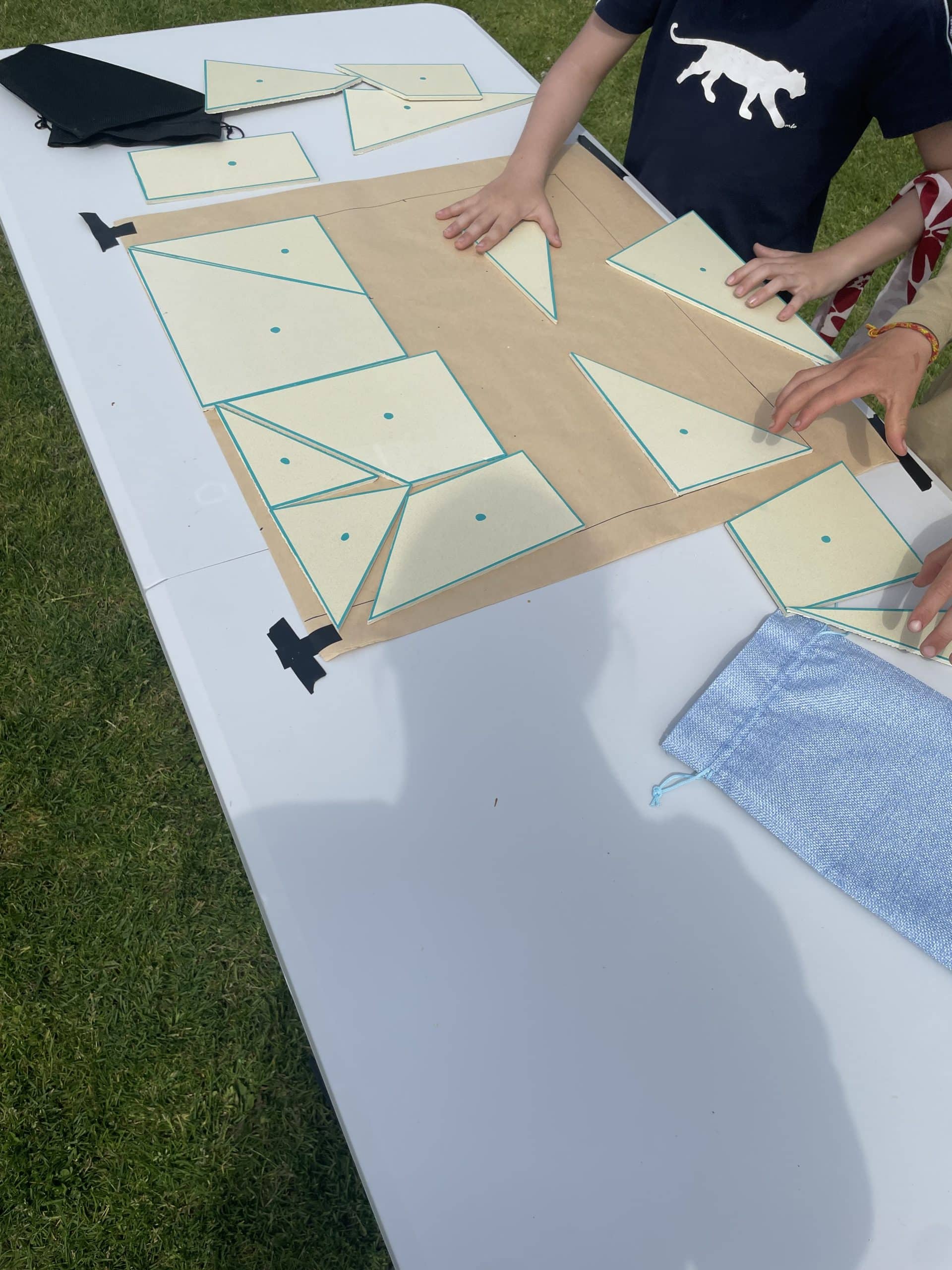 Jeu du tangram géant avec des participants qui les positionnent sur du papier
