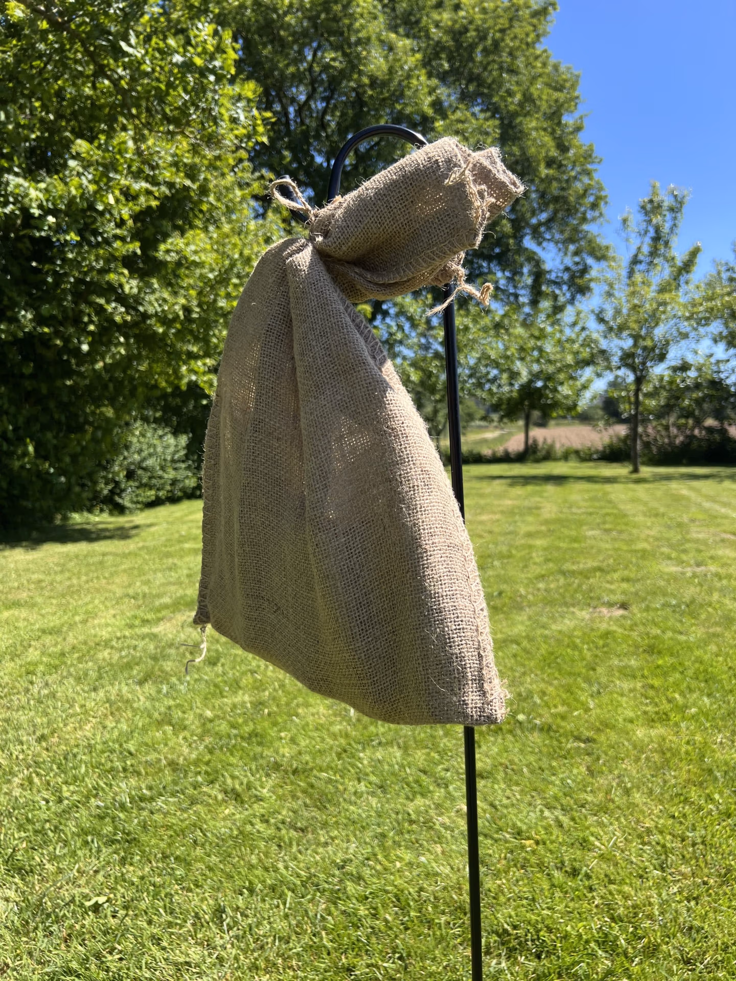 Sac en jute accroché en hauteur à un pied de berger