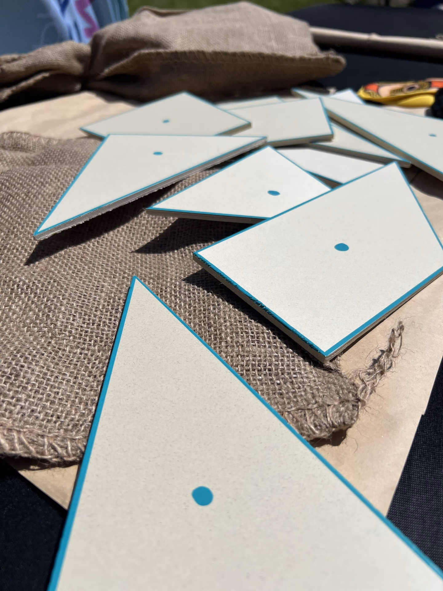 pièces de tangram avec point bleu posées sur des sacs de jute