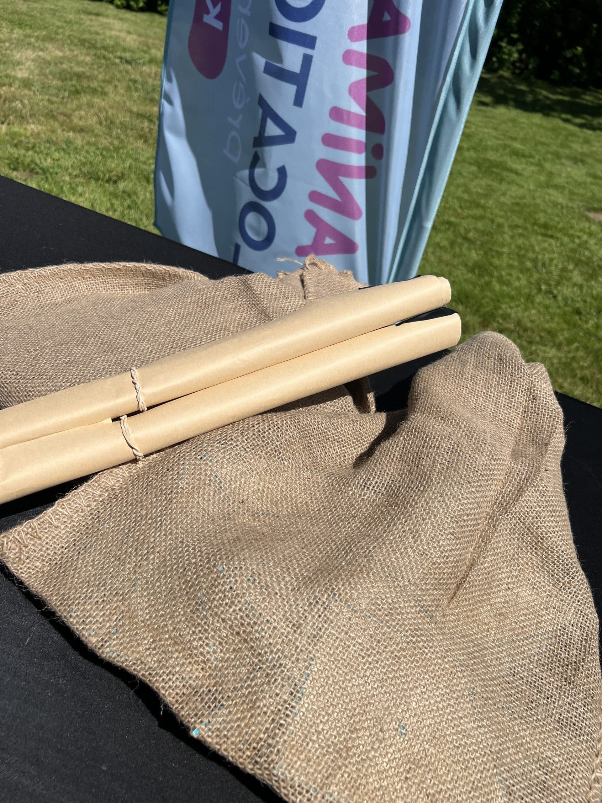 deux rouleaux en papier kraft positionné sur les sacs en jute comportant les Tangrams